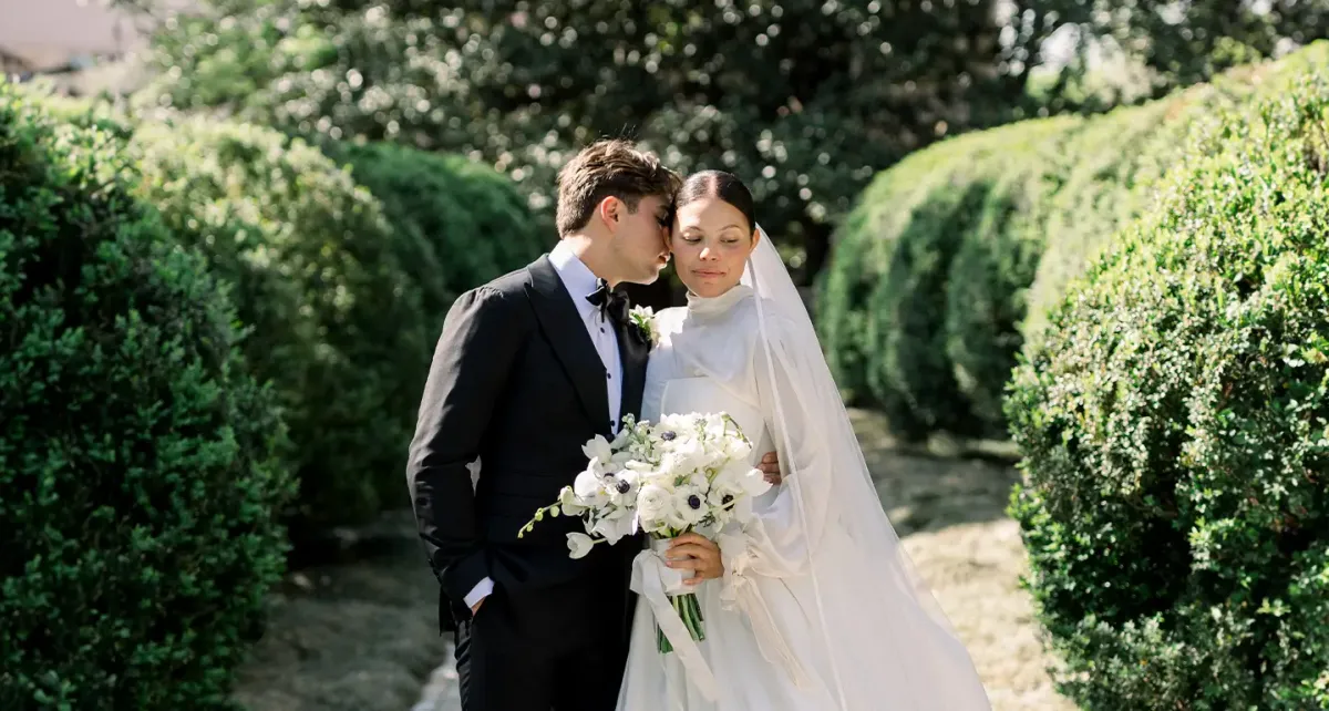 Bride and groom among manicured hedges