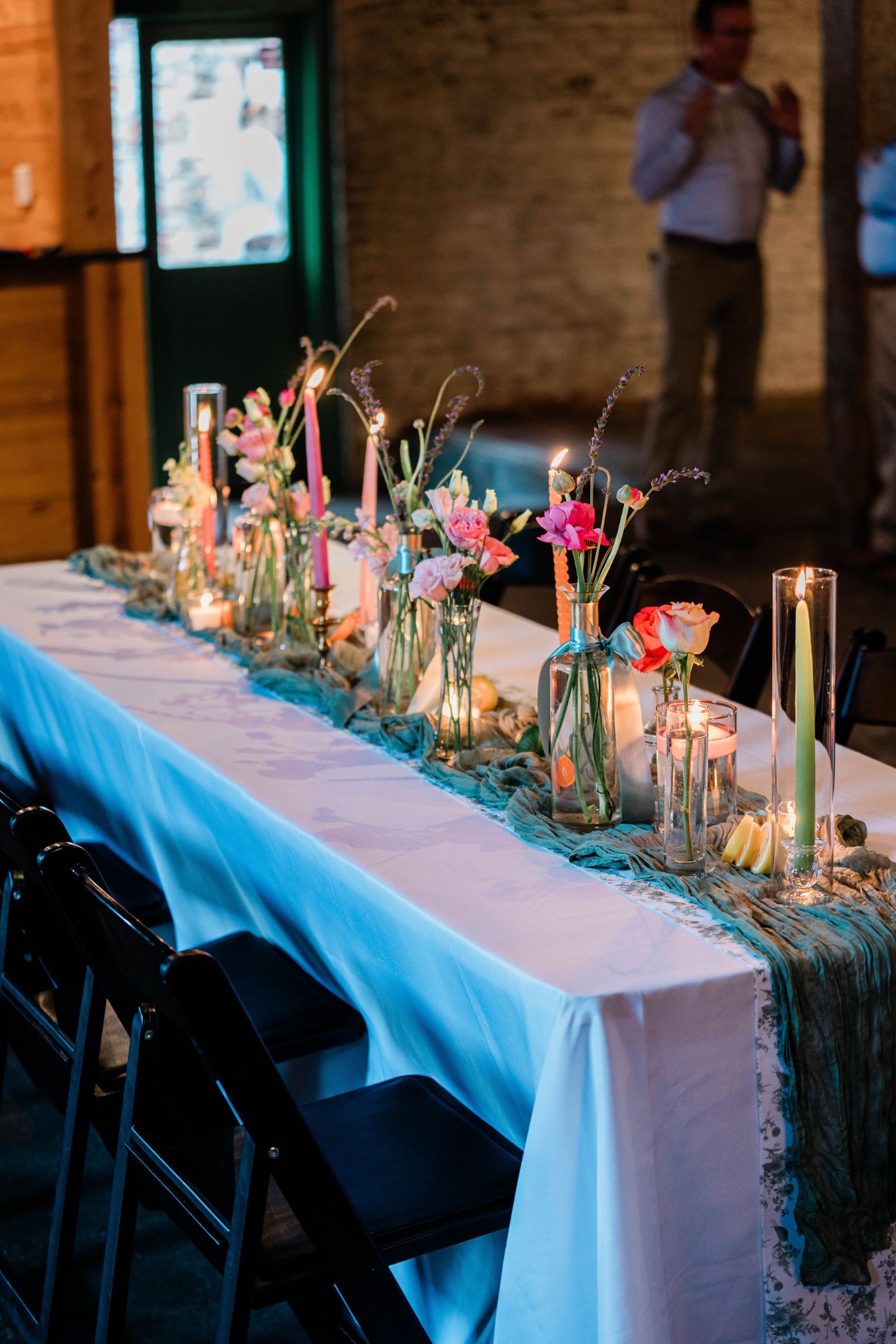 bright flowers in vases on a table with a white table cloth