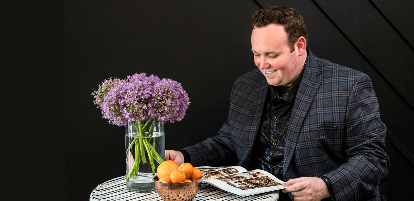 Caleb Butler sitting at a table and looking at the Wedding Society Book