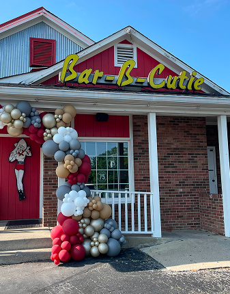 the front of the Bar-B-Cutie building decorated with colorful balloons